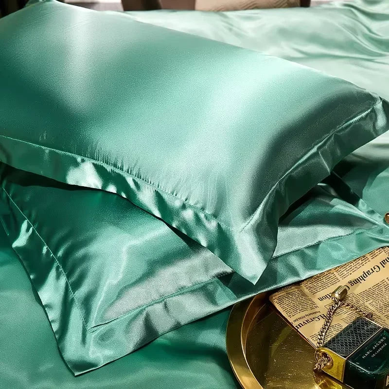 Green smooth satin-feel pillowcase set on a bed