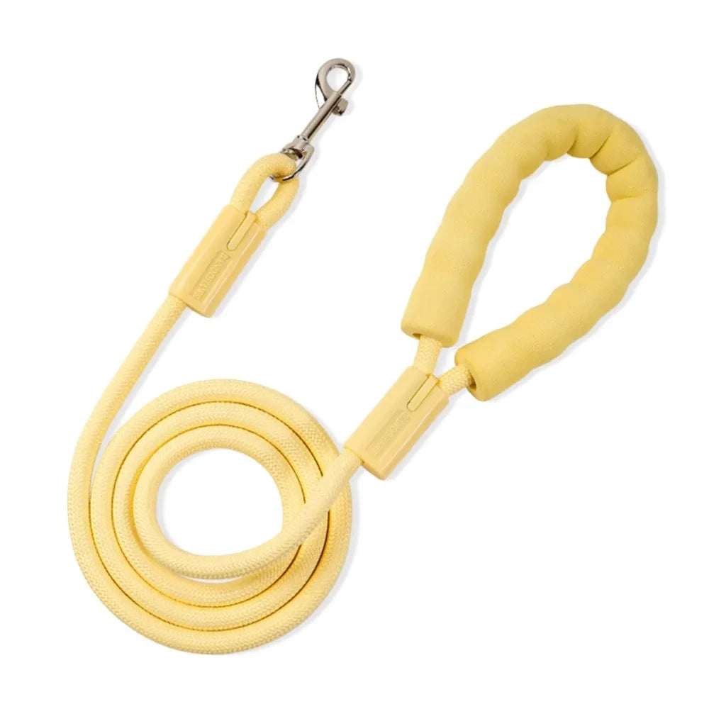 Yellow rope dog leash with padded handle and metal clasp on a white background