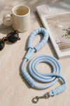 Sky blue rope dog leash with padded handle and metal clasp on a beige surface